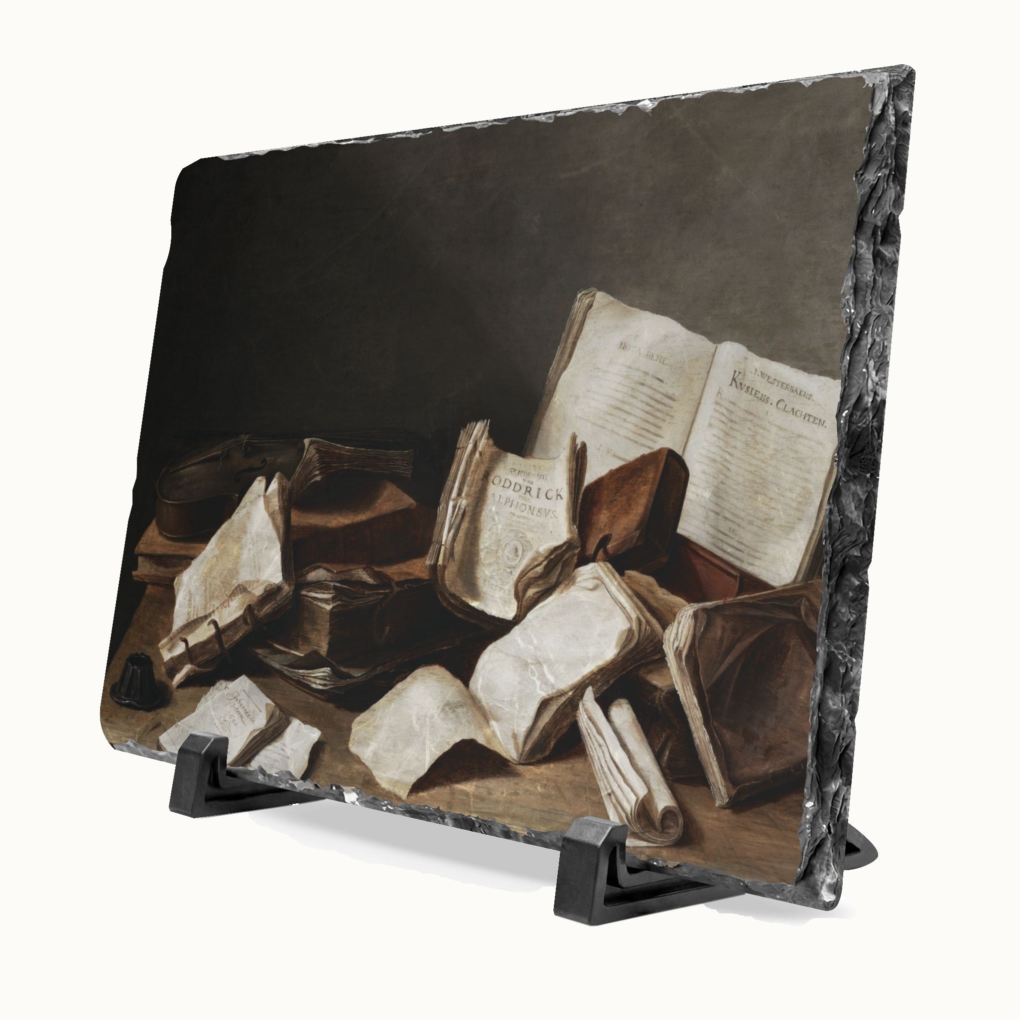 A rectangular slate plaque with a dark marble edge, featuring a classical still life painting of scattered old books and papers. The plaque is displayed on a black stand against a light off-white background.