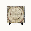A square decorative plaque or coaster featuring an antique celestial map design, displayed on a small black stand against a plain light background.