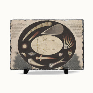 A rectangular slate serving board with a dark gray natural stone edge and a printed celestial illustration in the center, displayed on two small black stands against a light gray background.