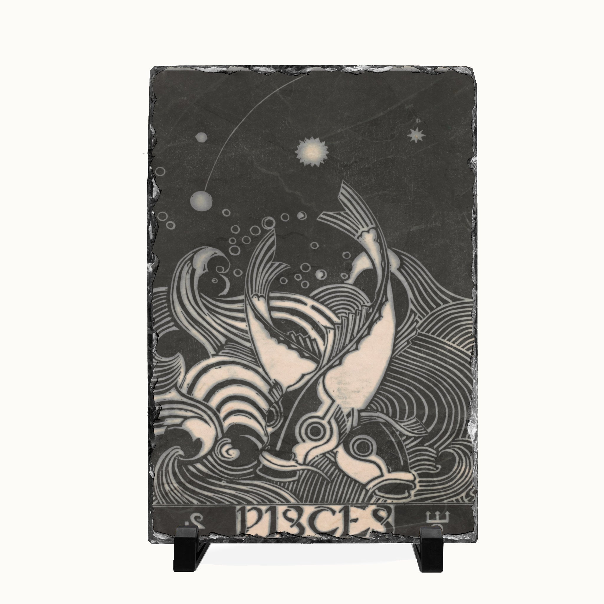 A rectangular black slate art plaque featuring a white line-art illustration of two fish and celestial elements, with the word 'PISCES' at the bottom, displayed on a small black stand against a light background.