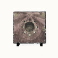 A square decorative slate tile featuring an antique celestial map design with moon phases, sun rays, and astrological symbols, displayed on a small black stand against a light off-white background.