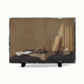 A rectangular decorative plaque or print featuring a still life painting of old books, an open book, a skull, and a small glass on a dark surface, displayed against a light gray background.