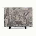 A rectangular slate serving board featuring a detailed black and white illustration of a classical mythological scene with a skeleton, winged figures, and animals, displayed on a clean white background with two small black display stands.