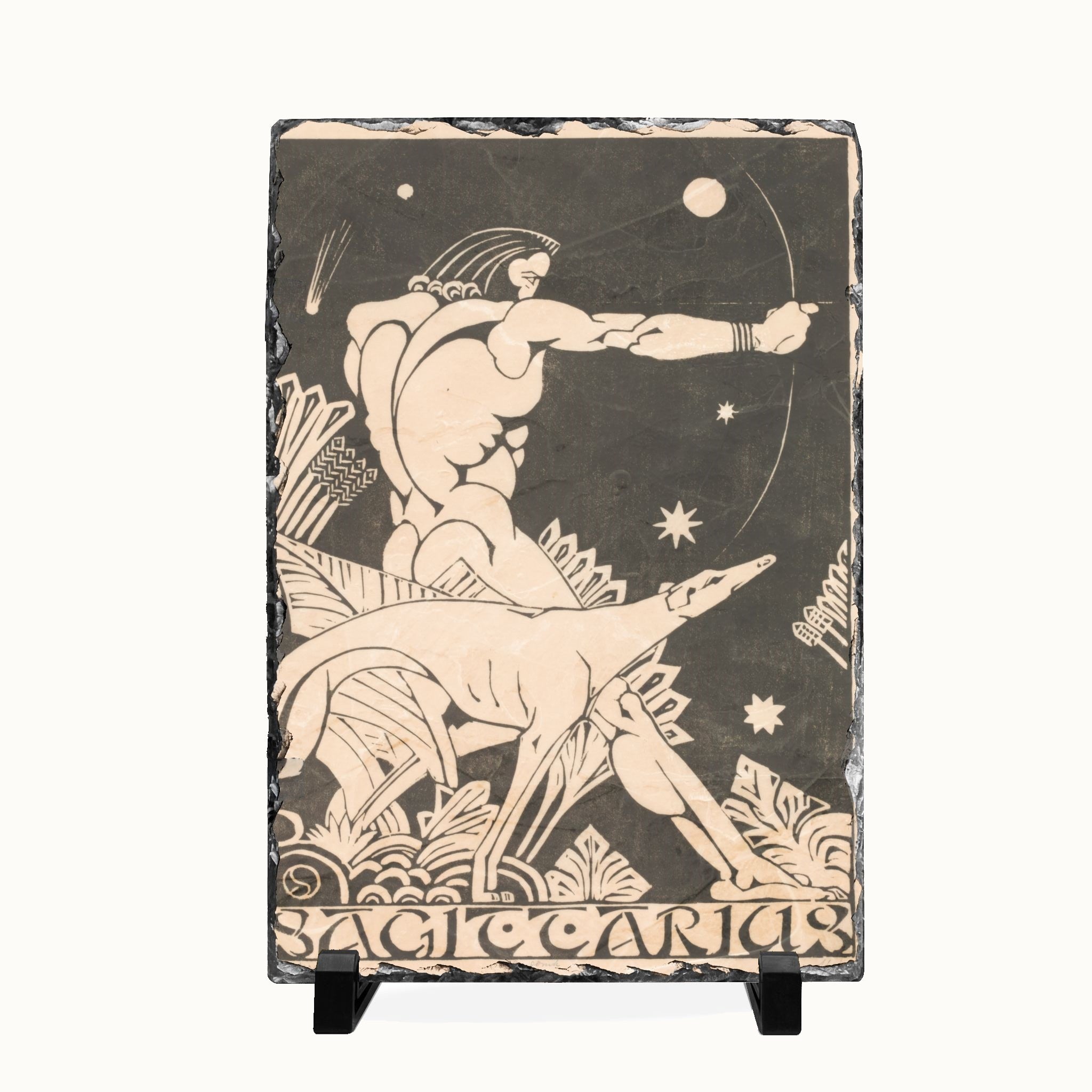 A rectangular black slate art plaque on a small black display stand, featuring a beige relief carving of a mythological figure riding a goat against a starry sky, with the word 'Sagittarius' at the bottom.